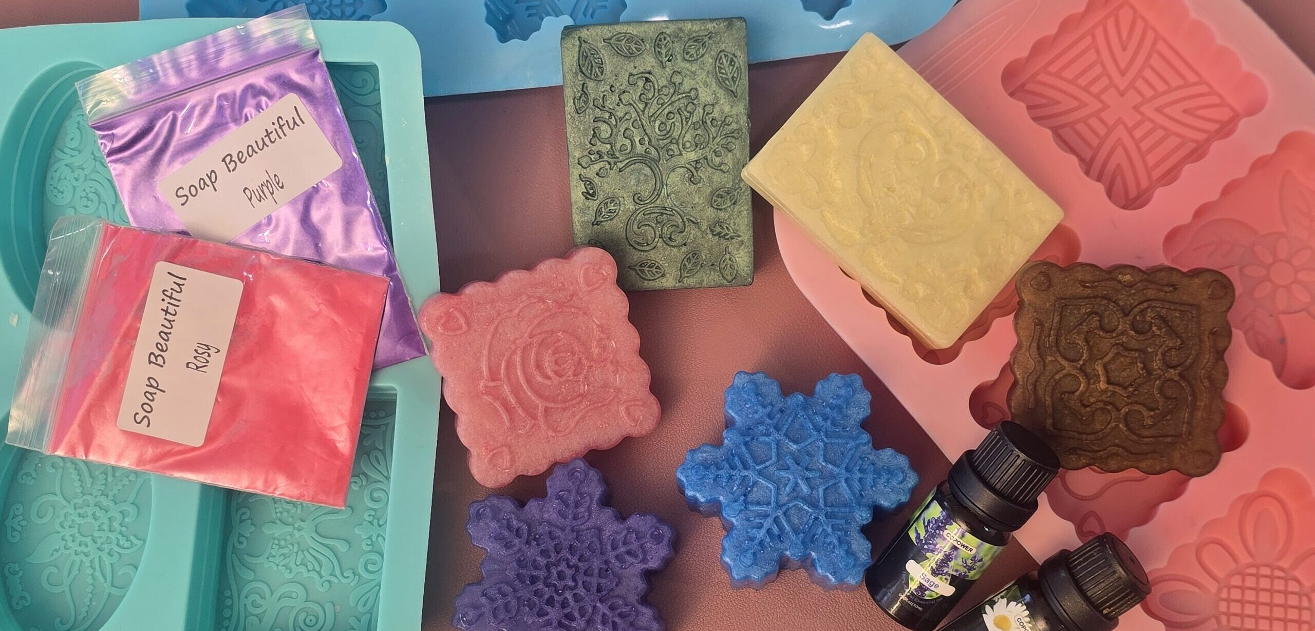 Seifengießen Workshop im makerspace Ideenw3rk. Viele bunte, selbstgemachte Seifen zusammen mit Silikonformen und Seifenmaterial